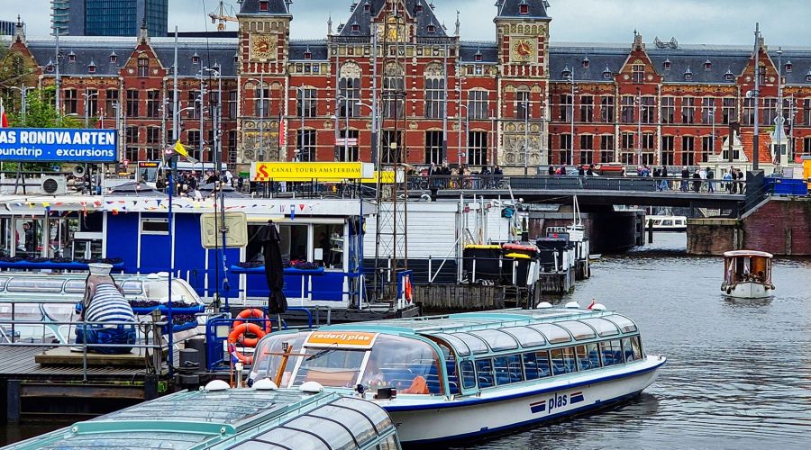 centralny dworzec kolejowy w Amsterdamie oraz przystań statków turystycznych na wycieczki po kanałach Amsterdamu