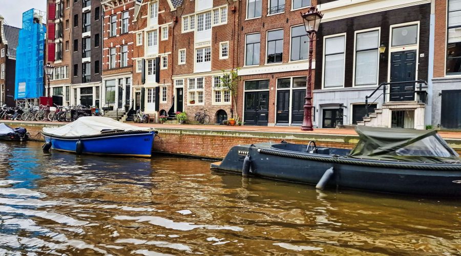 niderlandzkie kamieniczki przy jednym z kanałów Amsterdamu podczas wycieczki po jego kanałach