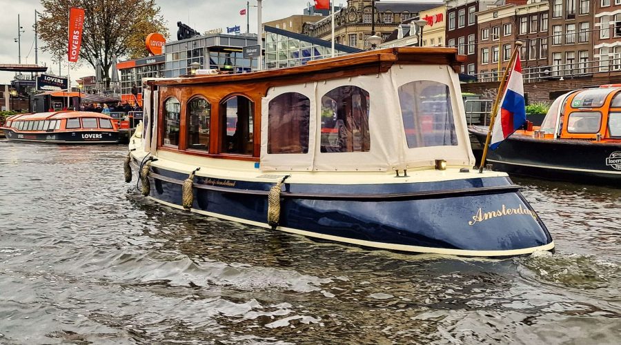 mały stateczek do turystycznych rejsów po kanałach Amsterdamu
